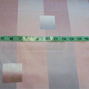 May include: A close-up of a pink and white striped fabric with a measuring tape across the middle. The tape reads 3 to 18 inches.