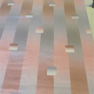 May include: A fabric with a striped pattern in shades of pink, gray, and white. The fabric has a subtle sheen and features a repeating pattern of squares.