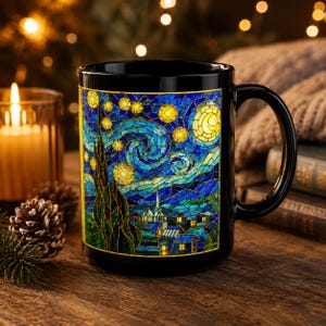 May include: Black ceramic mug featuring a stained-glass style depiction of Van Gogh's "Starry Night." The artwork includes swirling blue skies, yellow stars, and a crescent moon. The mug has a large handle and is set on a wooden surface.