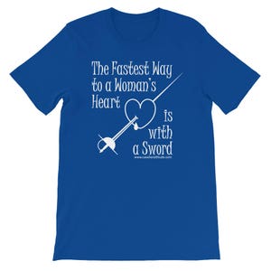 May include: A royal blue t-shirt with white text that reads "The Fastest Way to a Woman's Heart is with a Sword" and a white illustration of a sword piercing a heart. The website "www.cavalierattitude.com" is printed below the text.