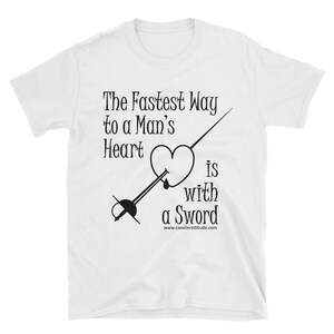 May include: White t-shirt with black text that reads "The Fastest Way to a Man's Heart is with a Sword" and a black illustration of a heart being pierced by a sword.