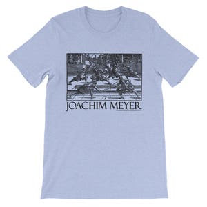May include: Pale blue t-shirt with a black and white print depicting a historical fencing scene. The text "JOACHIM MEYER" is printed below the image, along with a website address. The shirt has short sleeves and a crew neck.