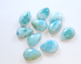 May include: A collection of ten teardrop-shaped, light blue and white gemstone cabochons. The cabochons have a marbled, iridescent appearance.