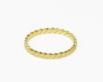 Può includere: Un anello dorato con un design intrecciato.
