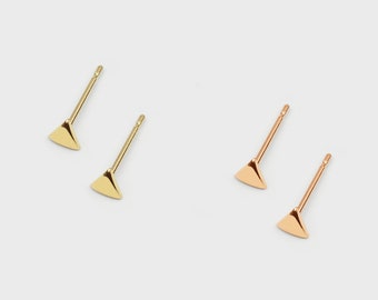 May include: A pair of minimalist triangle stud earrings. One pair is gold and the other is rose gold.