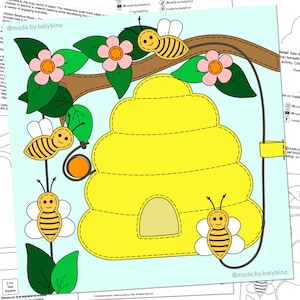 Puede incluir: Una página de libro sensorial de fieltro colorida con una colmena amarilla grande, tres abejas con alas blancas y rayas negras, y una rama de árbol marrón con hojas verdes y flores rosas. El diseño incluye detalles cosidos sobre un fondo azul claro.