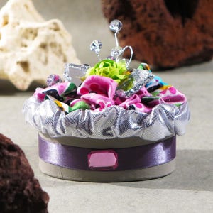 Decoratieve ovale kartonnen doos, roze en grijstinten met stof, groene bloem en andere decoratieve objecten