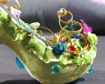 Chaussure décorative de couleur bleu/vert pailletée avec tissu, métal, fleurs, billes de verre, oiseau et décoration florale.