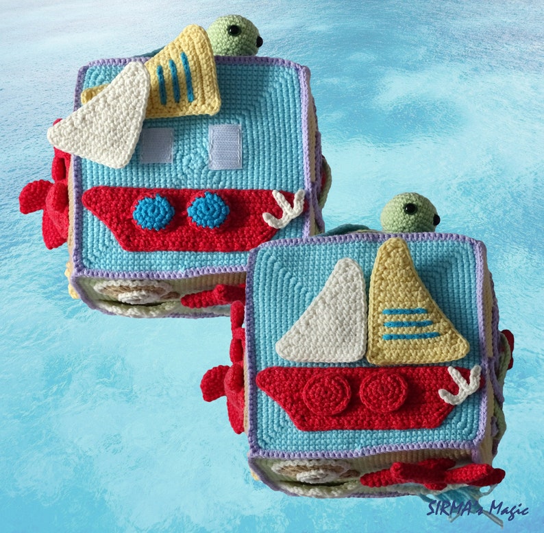 May include: Two crocheted blocks with a nautical theme. Each block features a sailboat with a red, white and yellow sail, a green turtle, and a blue and red boat. The blocks are made with a variety of colours, including blue, red, white, yellow and green.