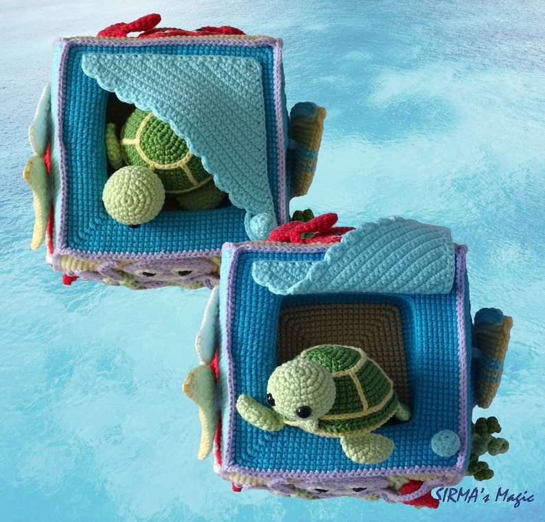 May include: Two crocheted boxes with a sea turtle design. The boxes are blue, green and purple with red accents. The boxes are open and each has a crocheted sea turtle inside.
