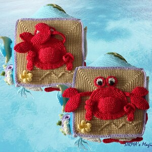 May include: Two crocheted square wall hangings featuring a red crab design. Each square has a tan background with a blue border and a yellow flower.