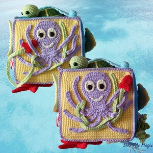 May include: Two crocheted square blocks featuring a purple octopus, green seaweed, and a red flower on a yellow background. Each block has a green turtle peeking out from behind it.