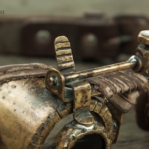 Op de afbeelding: Close-up van een steampunk-bril met een messing frame, leren banden en een messing hendel. De bril heeft een vintage uitstraling en is gemaakt met ingewikkelde details.
