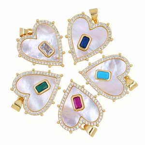 May include: Five heart-shaped pendants with gold-tone metal frames, each featuring a white mother-of-pearl inlay, a border of small clear cubic zirconia stones, and a single rectangular gemstone in the center in clear, blue, turquoise, green, or pink.
