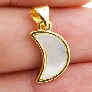 May include: Gold crescent moon pendant with a white mother of pearl inlay.