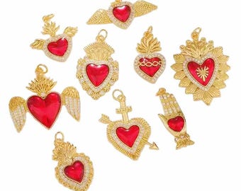 May include: A collection of gold-toned heart-shaped pendants with red centers. Some pendants feature wings, flames, or ornate detailing. The pendants are embellished with clear crystals, creating a sparkling effect. These charms are ideal for jewelry making.