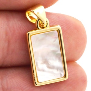 May include: Gold pendant with a rectangular white mother of pearl inlay.