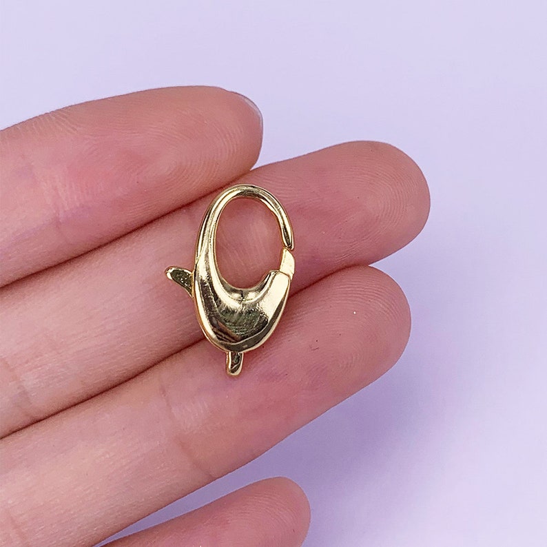 May include: Gold-toned metal lobster clasp, a type of fastener used for jewellery making, keychains, and other crafts.