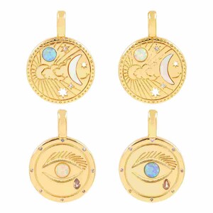 May include: Four gold-colored pendants. Two pendants feature a moon, sun, and stars design with an opal-like stone. The other two pendants have an eye design with an opal-like stone and a teardrop. Each pendant has a loop at the top.