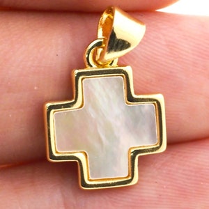 May include: A gold-toned cross pendant with a white mother-of-pearl inlay.