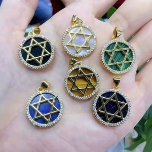 May include: Six gold pendants with a Star of David design. Each pendant features a different colored stone in the center, including black, white, green, brown, blue, and gold.