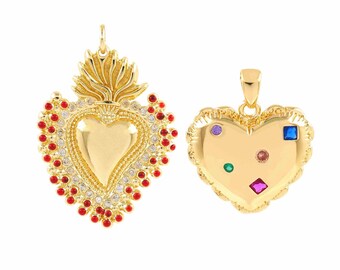 May include: Two gold heart-shaped pendants with jeweled accents. One pendant features a red and white jeweled border and a flame design. The other pendant has a gold heart with multi-colored jewels.