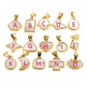 May include: A set of 15 gold-toned pendants with white mother-of-pearl inlays. Each pendant is shaped differently and features a letter from A to O.
