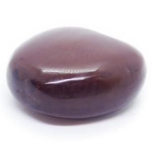 Puede incluir: Una piedra lisa y pulida de forma ovalada en color burdeos oscuro. La piedra tiene una superficie brillante y está sobre un fondo blanco. La piedra parece ser una piedra preciosa natural.