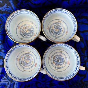 Set of four "rice eyes" porcelain teacups with five-clawed dragons motif, gold trim, made in China, blue and white, calligraphy, imperial