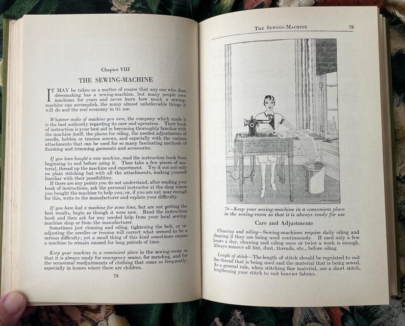 Puede incluir: Una p&aacute;gina de libro abierta titulada Chapter VIII THE SEWING-MACHINE, con texto negro sobre papel blanco y un dibujo lineal en blanco y negro de una persona usando una m&aacute;quina de coser sobre una mesa, con un cubo al lado y texto instructivo.