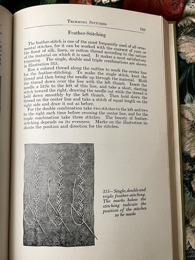 Puede incluir: Una p&aacute;gina de un libro titulada Trimming Stitches, p&aacute;gina 183, con texto sobre el punto de pluma y una ilustraci&oacute;n en blanco y negro numerada 315 que muestra t&eacute;cnicas de punto de pluma simple, doble y triple con agujas e hilo.