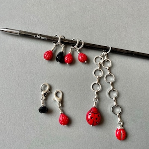 May include: A set of six ladybug stitch markers, including a chain with two ladybugs, two black bead markers, and two red ladybug markers. The markers are attached to a knitting needle labeled "4.50 mm".