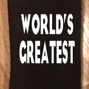 May include: Black sock with the words "WORLD'S GREATEST" in bold white letters. The sock is made of a soft material and is likely for everyday wear. The text is centered on the sock.