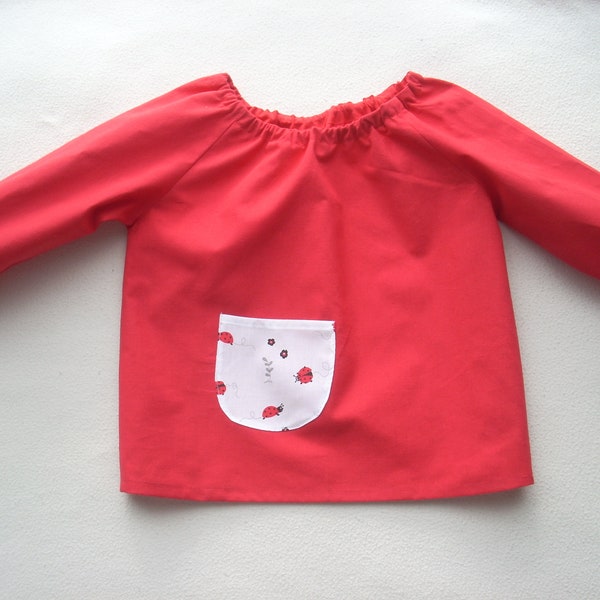 Blouse pour activités manuelles en coton rouge, poche coccinelles, pour enfant à partir de 3 ans.