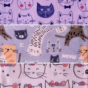May include: Purple fabric with a repeating pattern of various cartoon cats. Some cats are wearing bow ties, some have milk cartons, and some have flowers on their heads. The text "Meow" is printed on the fabric.