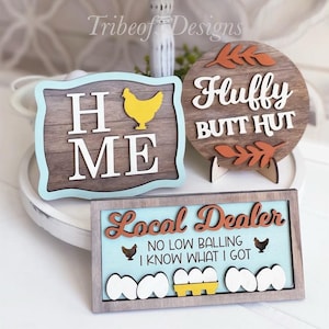 Puede incluir: Una bandeja de tres niveles decorada con letreros de madera con tem&aacute;tica de pollo. Los letreros dicen "Just a girl who loves chickens", "Bless our nest", "Home", "Fluffy butt hut", y "Local dealer, no low balling, I know what I got".