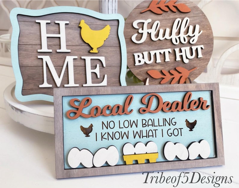 Puede incluir: Tres letreros de madera con tem&aacute;tica de granja. El primer letrero dice "Home Me" con una silueta de pollo amarilla. El segundo letrero dice "Fluffy Butt Hut" con hojas marrones. El tercer letrero dice "Local Dealer No Low Balling I Know What I Got" con una silueta de pollo marr&oacute;n, una caja de huevos amarilla y huevos blancos.