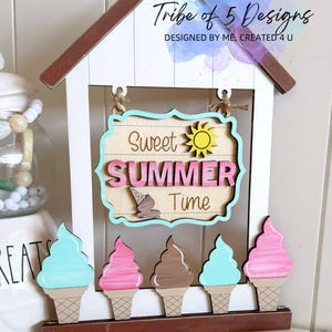 May include: Wooden summer-themed sign with a house-shaped frame. The sign reads "Sweet SUMMER Time" with ice cream cone accents. Five wooden ice cream cones in various colors are below the sign. The sign is decorated with a wooden bead garland.
