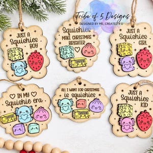 Può includere: Sei ornamenti in legno smerlato con testo inciso e colorati squishies a cartone animato. I disegni includono frasi come Just a Squishies Boy, Just a Squishies Girl, Just a Squishies Kid, In My Squishie Era e All I Want for Christmas is Squishies.