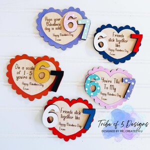May include: Wooden heart-shaped Valentine's Day decorations with scalloped edges. Each heart features the numbers 6 and 7, with various colors and patterns. Text includes phrases like "Hope your Valentine's day is solid" and "Friends stick together like."