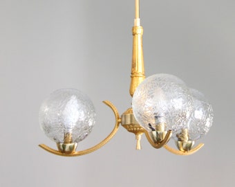 Old chandelier in gilded metal, brass and vintage cracked glass globes design decoration