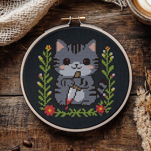 A cross-stitch pattern featuring a gray cat holding a bloody knife, surrounded by floral elements, set against a black background