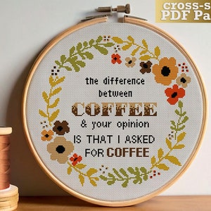 Może przedstawiać: Wzór do haftu krzyżykowego PDF dla obręczy z wieńcem kwiatowym i tekstem "the difference between COFFEE & your opinion IS THAT I ASKED FOR COFFEE".