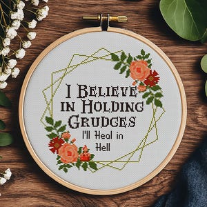 Może przedstawiać: Wzór do haftu krzyżykowego z wieńcem kwiatowym i tekstem "Wierzę w pielęgnowanie urazów Zagoję się w piekle".