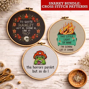 Puede incluir: Tres patrones de punto de cruz en aros de madera. Uno presenta una calavera y la cita "TO QUOTE HAMLET ACT III, SCENE III, LINE 87 'NO'". Otro muestra un incendio en un contenedor de basura con el texto "THIS LITTLE LIGHT OF MINE I'M GONNA LET IT SHINE". El tercero representa una rana con el texto "the horrors persist but so do I".