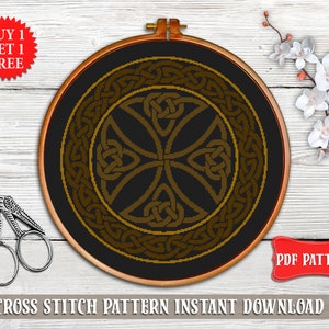 May include: A cross stitch pattern featuring a Celtic knot design in gold on a black background. The pattern is in a round hoop and the text "PDF PATTERN" is visible in the lower right corner.