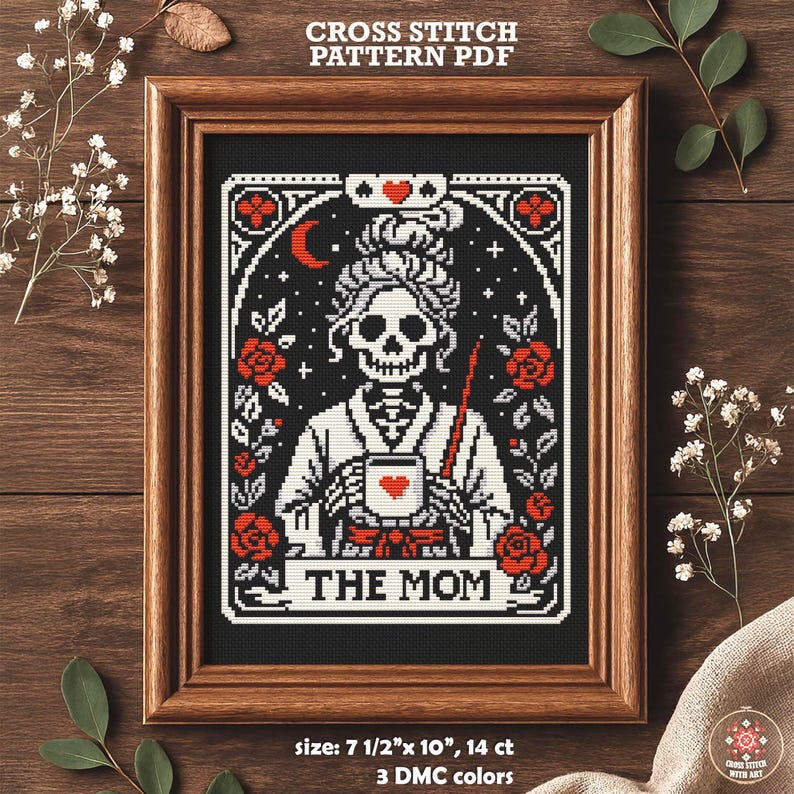 Cross-stitch pattern PDF featuring a skeletal figure holding a mug with a heart, surrounded by roses and stars. The design is framed in a wooden hoop, with the text "THE MOM" at the bottom. The pattern measures 7.5" x 10".