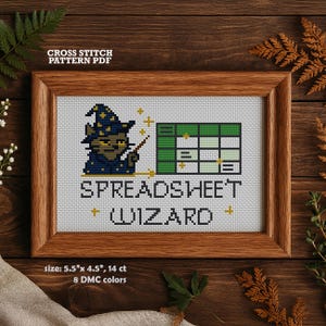Könnte beinhalten: Kreuzstichmuster-PDF in einem Holzrahmen. Das Design zeigt einen Zauberer mit einer Tabelle, den Text "SPREADSHEET WIZARD" und die Größe beträgt 14 cm x 11,4 cm. Das Muster verwendet 8 DMC-Farben.