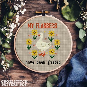 Op de afbeelding: Een kruissteek borduurring met een beige achtergrond. Het ontwerp toont een witte gans omringd door gele zonnebloemen en de tekst "MY FLABBERS have been gasted" in rood en zwart. De woorden "CROSS STITCH PATTERN PDF" staan onderaan.
