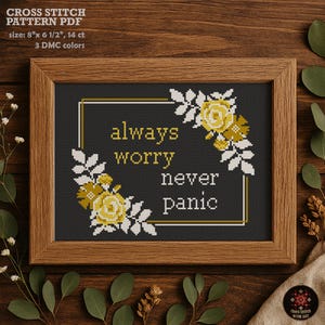 May include: A framed cross-stitch pattern with the text "always worry never panic." The design includes yellow roses and white leaves. The frame is brown, and the background is dark gray. The pattern size is 8" x 6 1/2".